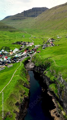Experience the tranquility of Gjogv village in the Faroe Islands, surrounded by dramatic landscapes and rolling hills.