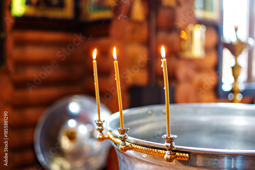 Candles light up a metal basin in a quiet setting