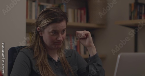 A woman at work, pausing out of frustration and stress and fidgeting with her pen. She drops the pen, picks it up, clicks it, and presses it to her heads.