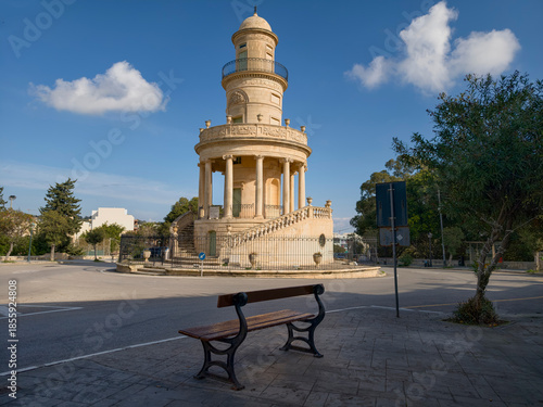 Lija, Malta — historic rotunda in a sunlit town square with colonnade and surrounding limestone facades