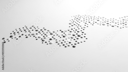 Gray and white water droplets on a smooth surface forming a wave pattern