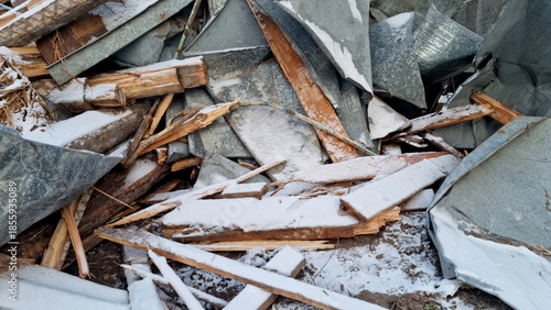 Garbage dump. Close-up of a demolished wooden house in the snow. Winter background. 
Environmental pollution.
