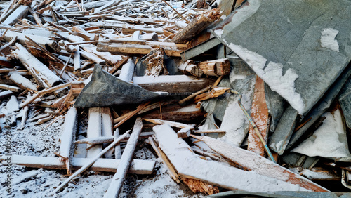 Garbage dump. Close-up of a demolished wooden house in the snow. Winter background. 
Environmental pollution.

