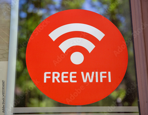Free wifi sign sticker on glass window closeup.