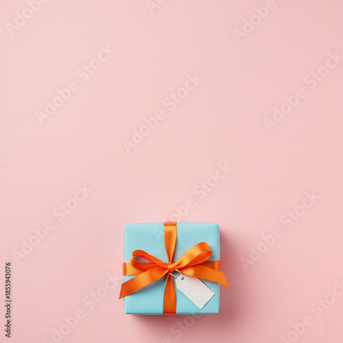 Holiday background with pastel pink backdrop, one wrapped gift box centered 