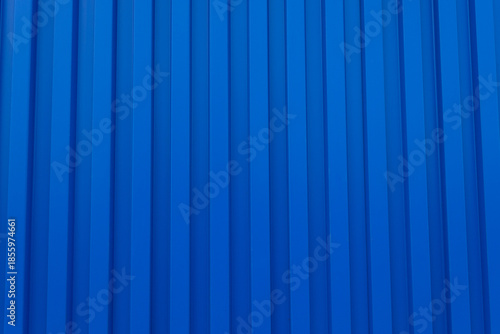 Blue Corrugated Metal Sheet Texture Background,Close-up of a vibrant blue corrugated metal wall with vertical ridges. This high-resolution texture features a repetitive geometric pattern, ideal for