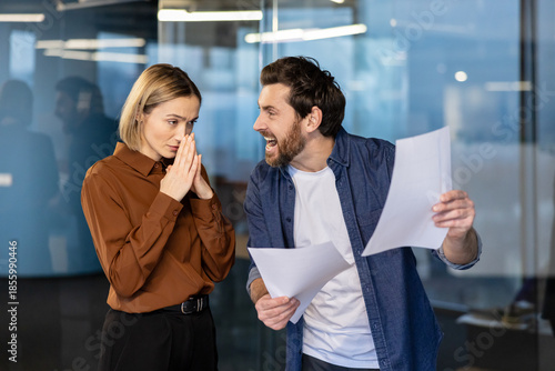 Photos Angry male boss yelling at a stressed female employee holding her hands together