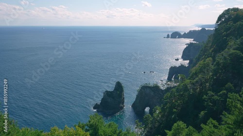 Dramatic Kitayamazaki coastline in Iwate Japan. Sharp rock formations and sea arches stand in the blue Pacific Ocean on a sunny day in October.