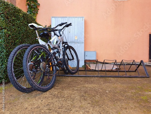 Beautiful photo of parked bikes bicycles outside on the street in urban city in front of the wall hd resolution horizontal backdrop image perfect for campaigns