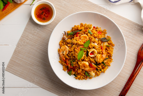 Seafood Tom Yum Fried Rice,Stir fried rice with shrimp and squid with chilli sauce on white plate.Top view.