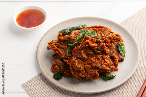 Deep fried fish patty or Thai Fish cake with crispy basil (Tod mun pla) in a plate.