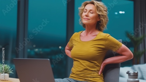 Woman suffering from lower back pain while working late at night