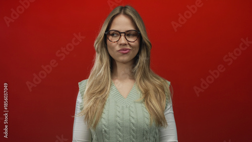 Photos Young blonde caucasian woman holds hands together in a plotting gesture in a studio photo shoot; cunning mischief strategy