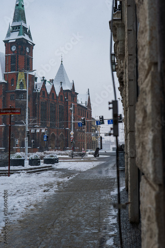 Winter street in Wroclaw with Neo Gothic clock tower and tram wires