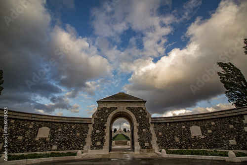 Fotografie Tyne Cot Cemetery and Memorial under dramatic storm clouds in Zonnebeke, Belgium