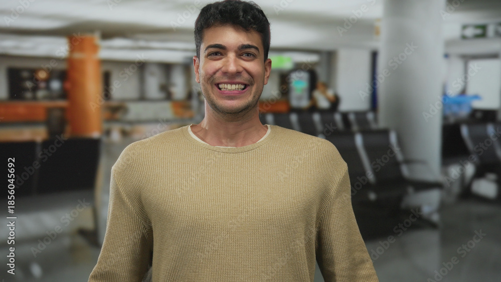 Φωτογραφία Man flashes broad face to cheer passengers in airport where young hispanic traveler stands by terminal during waiting male anticipation