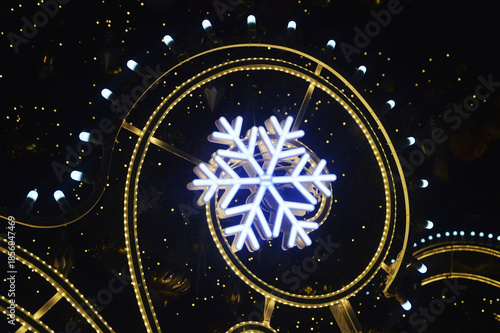 A fragment of Christmas street decorations, golden garlands and festive illuminations against the night sky.