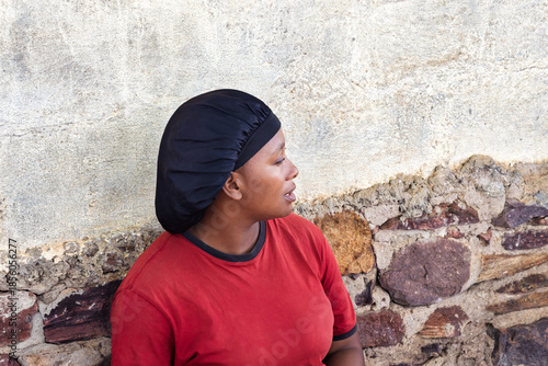 Fotografie village african woman portrait, satin hair cap bonnet , outdoors in the nature,