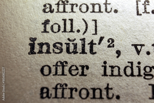 Foto Word insult printed on a dictionary page, macro closeup