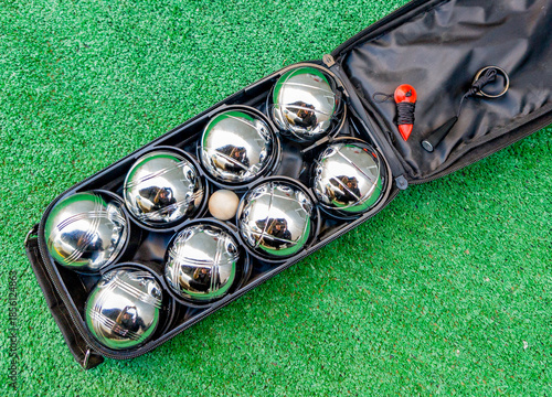 A set of pétanque balls in its case, with a jack, a measuring cord, and a magnet for picking up the balls without bending over.