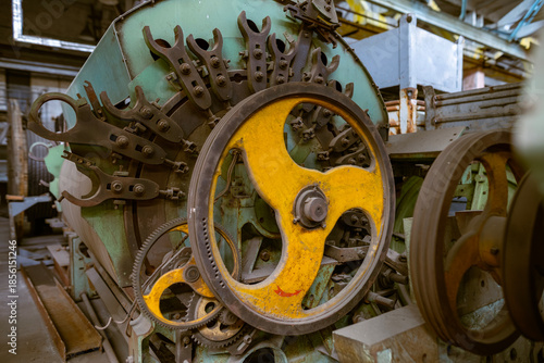 Photos Yellow flywheel on industrial machinery detail
