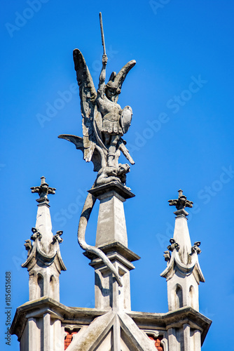 Sculpture of angel defeating the dragon on the top of the spire of the facade of the Roman Catholic Cathedral of St. Nicholas in Kyiv, Ukraine. Traditional gothic decor