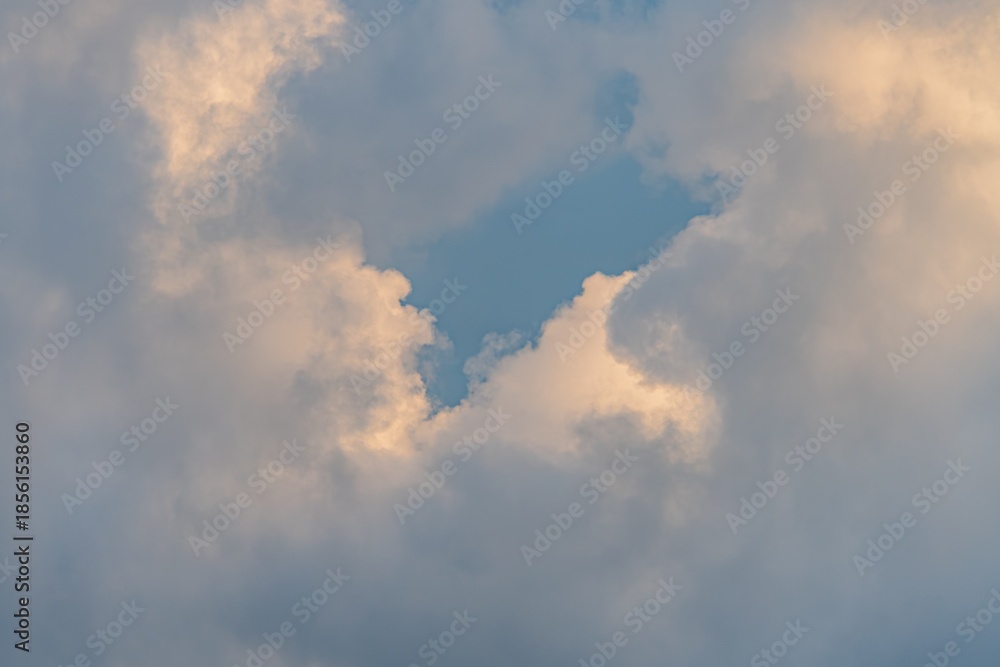 Obraz premium Wide sky filled with fluffy white clouds, viewed from below Soft whites, subtle grays, and blues dominate the color palette No objects or figures present