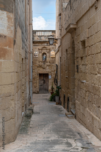 Small and simple dead-end street ending with a small Virgin Mary shrine, creating a touching and intimate view of everyday life in a traditional Maltese town Iz-Zeytun, Malta, 10 DEC 2025.