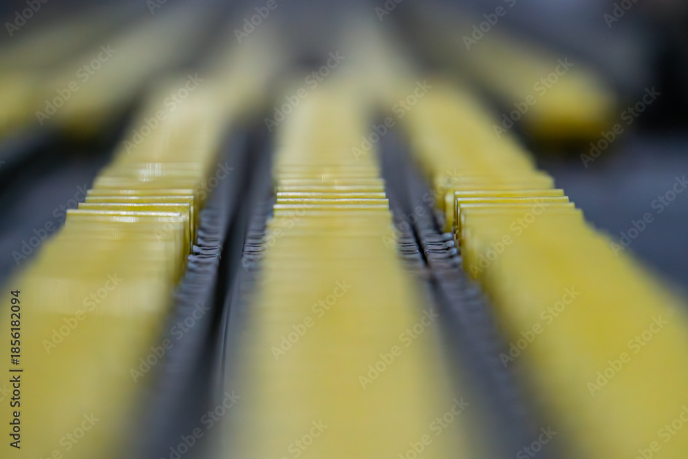 Φωτογραφία Close-up of yellow industrial parts on a conveyor, reflective and possibly metal