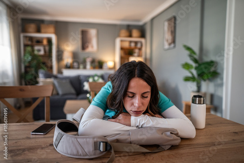 Exhausted female nurse sleeping on a table at home