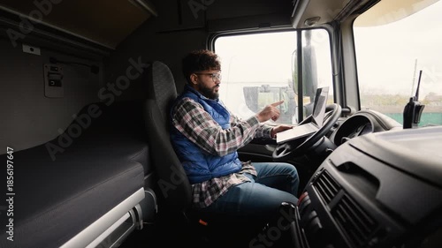Professional truck driver using laptop in cabin