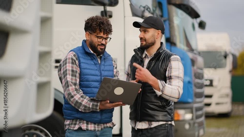 Truck drivers discussing logistics and shipping on a laptop