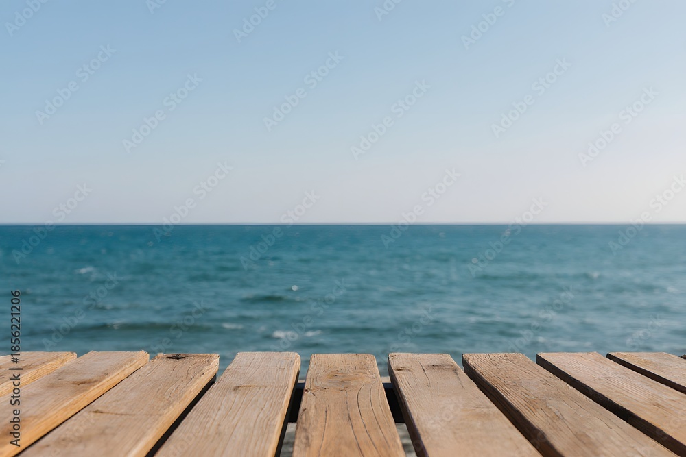 Naklejka premium Wooden planks provide a neutral foreground to a vast ocean view with clear horizon