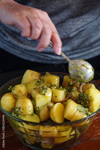 A woman prepares a delicious fresh potato salad