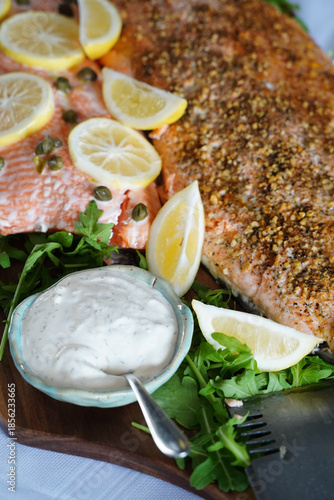 Delicious fresh salmon prepared on a platter with lemon and salad