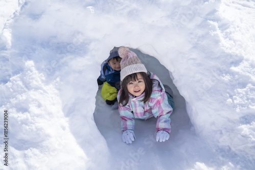 Photos 雪の公園のかまくらで遊ぶ子供