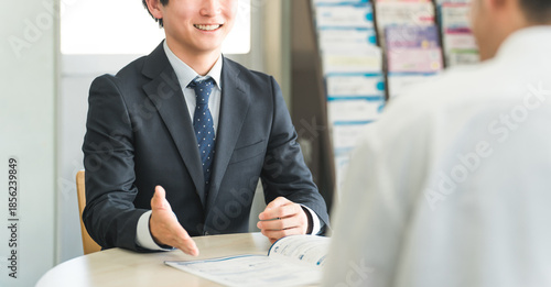 Fotografía A young Asian businessman negotiating, serving and meeting with a male customer