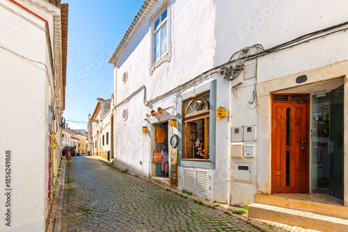 A whitewashed cobblestone street through the historic old town of Lagos, Portugal, in the Algarve region of Southern Portugal.