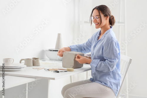 Young female potter cutting...
