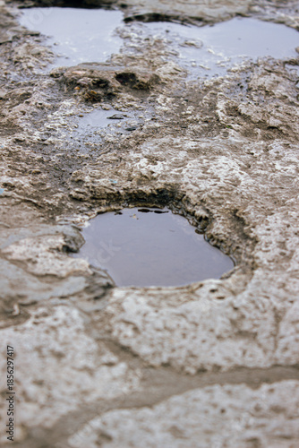 Puddle on uneven ground surface after rain close up