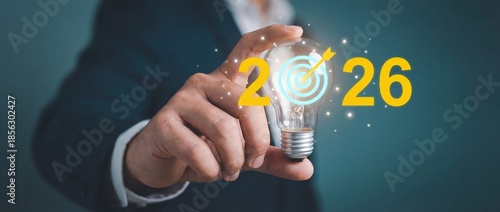 Hand holding light bulb with 2026 target symbol for business strategy and future corporate innovation