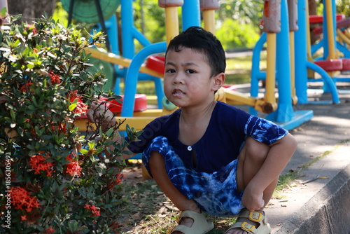 Portrait of a children in a park, A 3-year-old boy is happily walking in the park, wearing an Asian-style blue and white shirt.