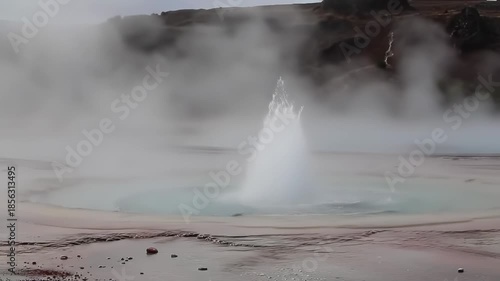 Geyser Erupts with Steam and Water in Natural Landscape
