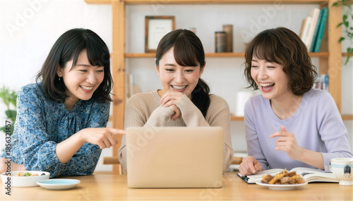 ノートパソコンを囲んで楽しそうに談笑する日本人女性3人