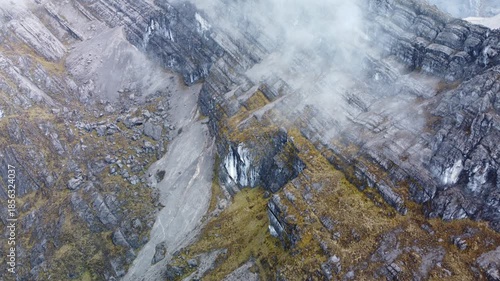 Aerial view from the top of the Carstensz Pyramid with clouds and a mysterious atmosphere.