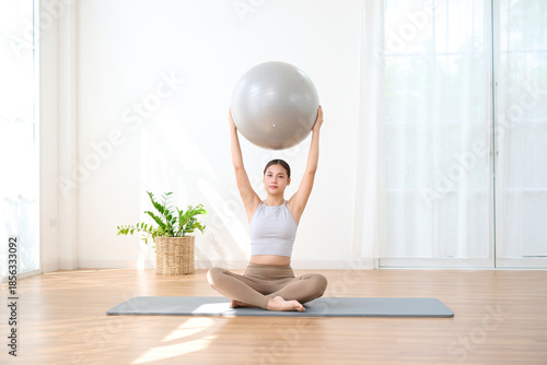 Woman is exercising with a large yoga ball