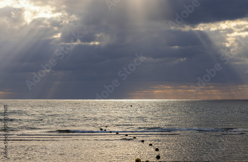 Beautiful sunset on the Mediterranean Sea with dark clouds and sun rays