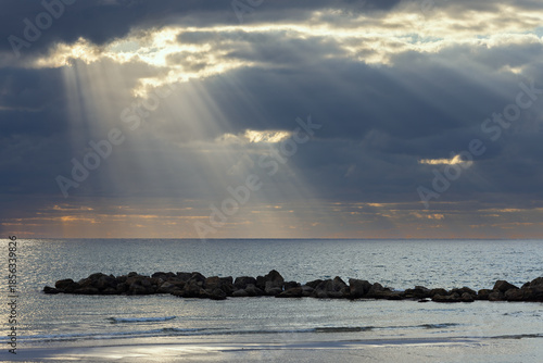 Beautiful sunset on the Mediterranean Sea with dark clouds and sun rays