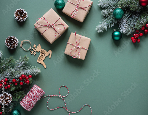 Christmas festive flat lay with wrapped gifts and pine branches on green background