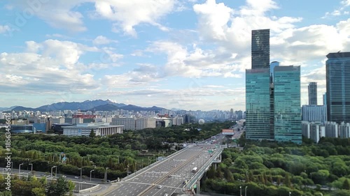 Timelapse, Urban cityscape skyline with modern high rise buildings and wide boulevard under bright blue sky, clean contemporary daytime mood